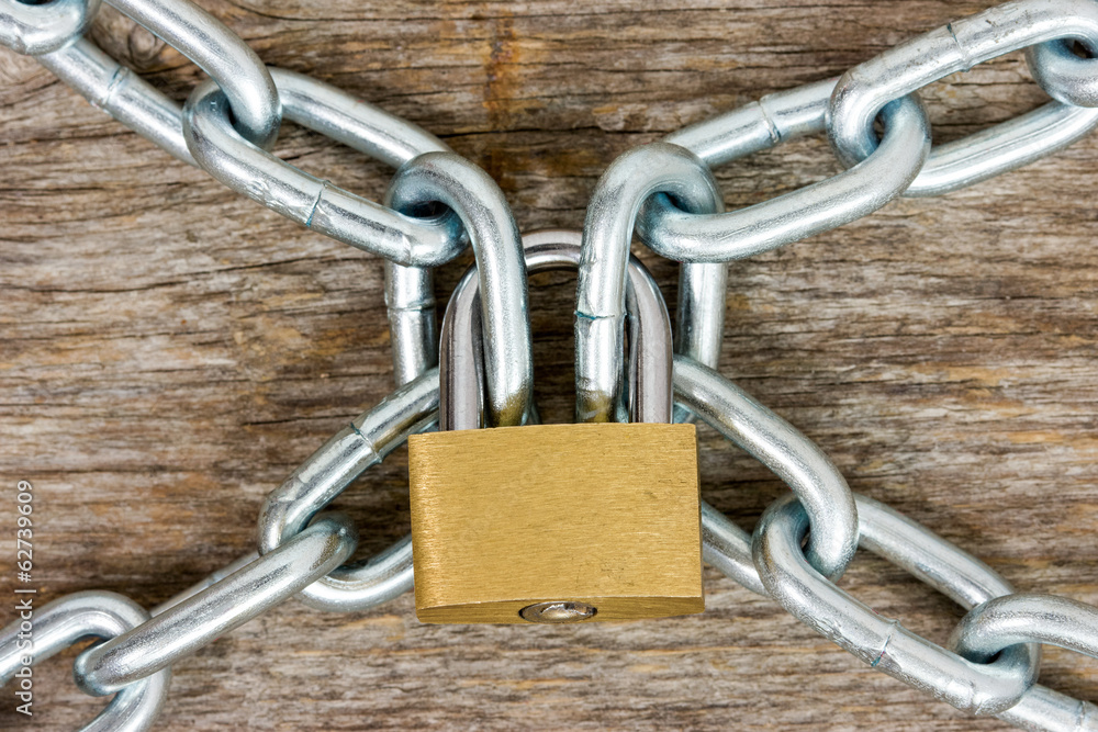 Chains and padlock on the wooden background Chains and padlock on the wooden background