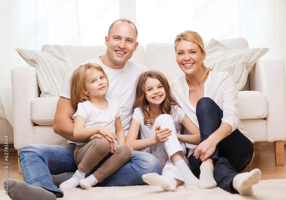 parents and two girls sitting on floor at home