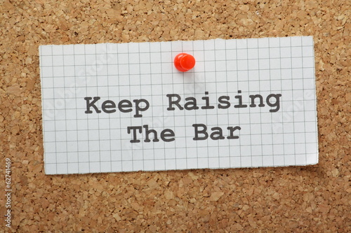 The phrase Keep Raising the Bar on a piece of graph paper