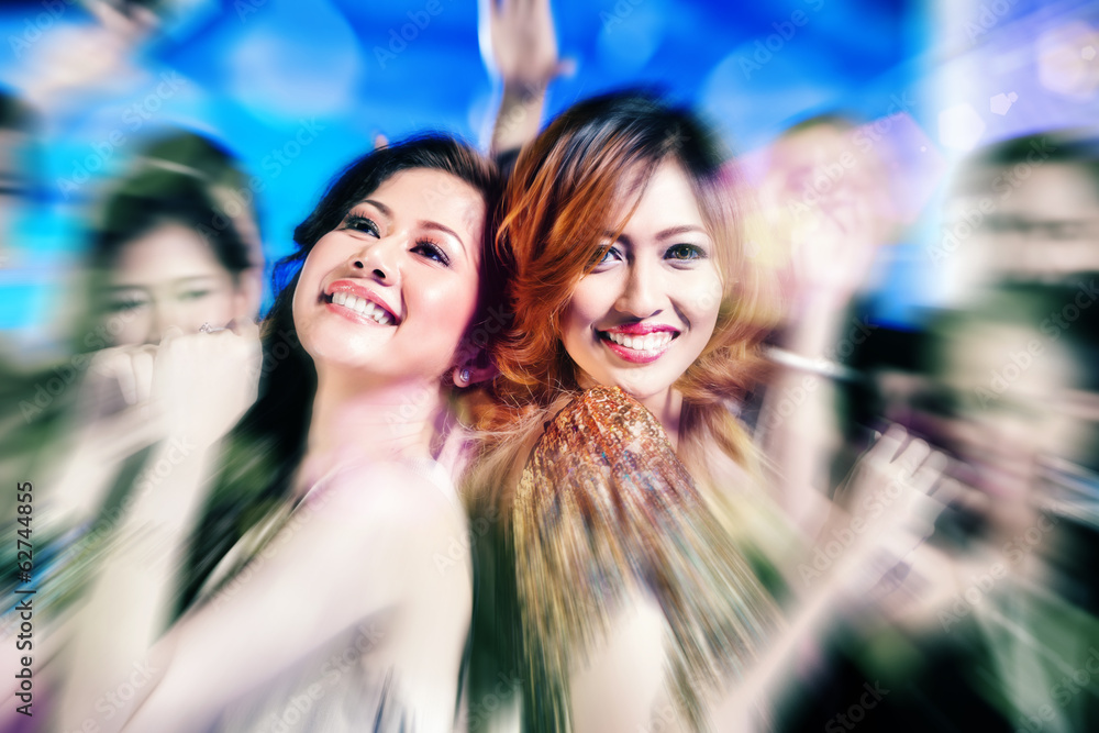 Obraz premium Asian girls partying on dance floor of disco nightclub