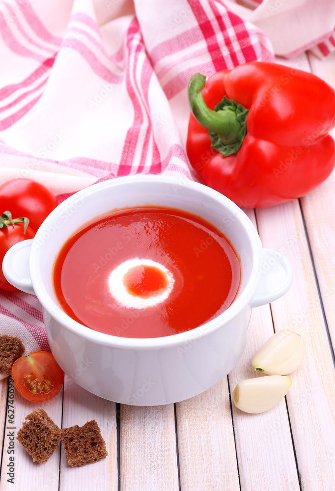 Tasty tomato soup and vegetables on wooden table Tasty tomato soup and vegetables on wooden table