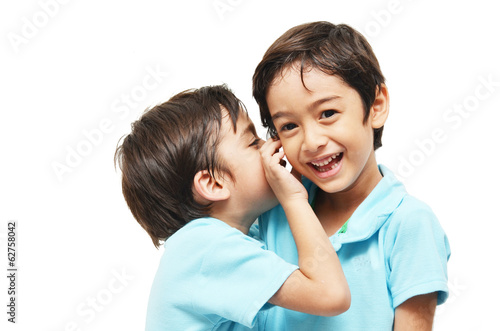 Little sibling boys sharing a secret on white background