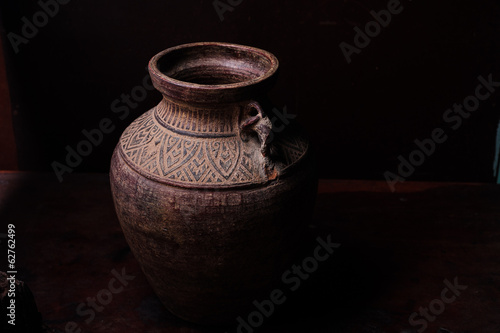 Earthenware jug standing on dark room