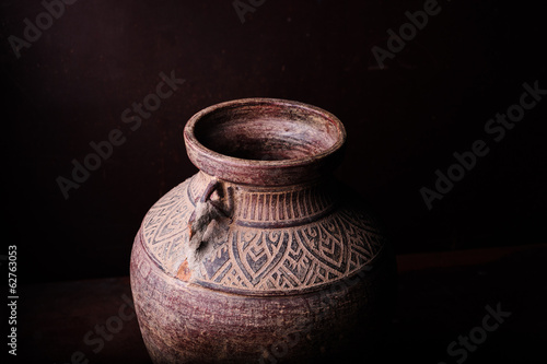 Earthenware jug standing on dark room