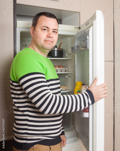  guy searching for something in refrigerator
