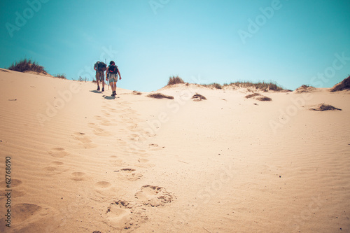 couple climbing sand dunes