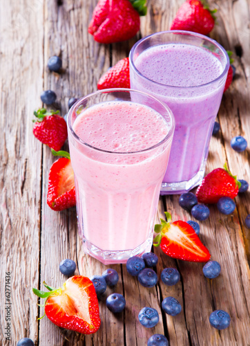 Fresh milk, strawberry and blueberry drinks on wodeen table, photo