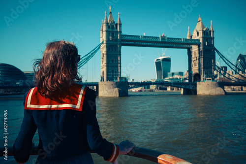 Photography Young woman on boat looking at Tower Bridge in London