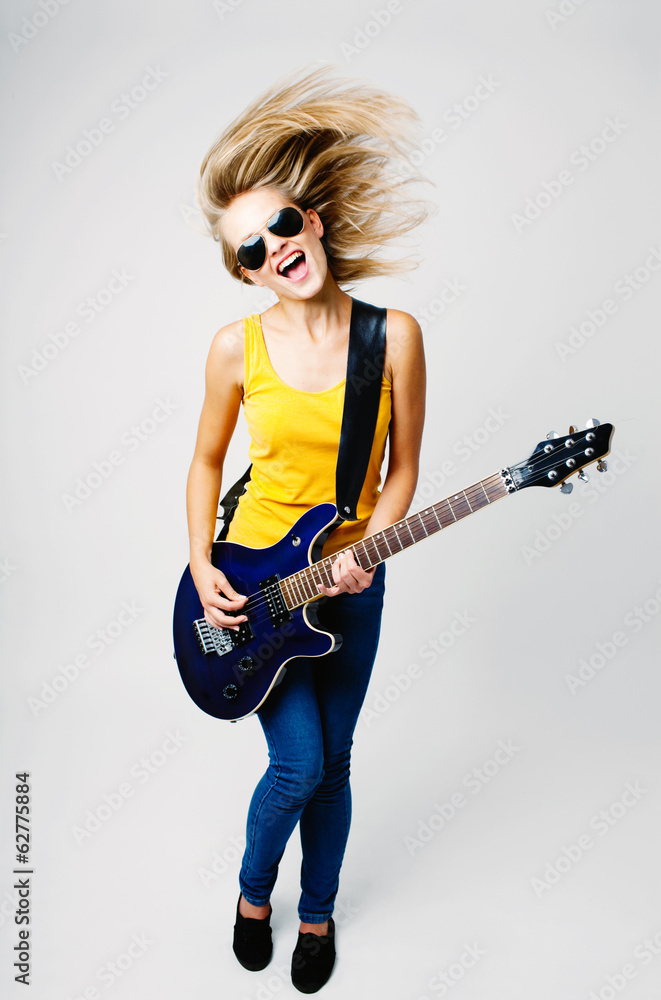 Young woman wave hair and play on guitar Young woman wave hair and play on guitar