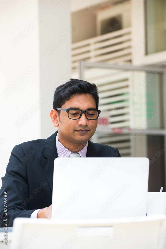 young indian business man on laptop and coffee at a cafe young indian business man on laptop and coffee at a cafe