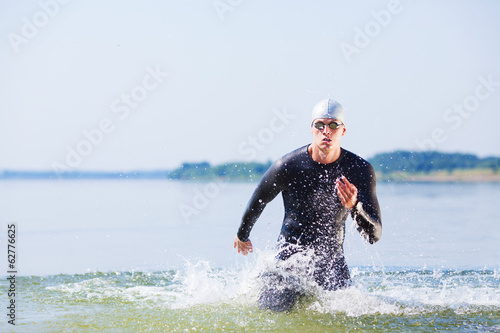 Canvas Print Triathlete running out of the water