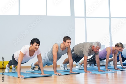 Group doing push ups in row at yoga class