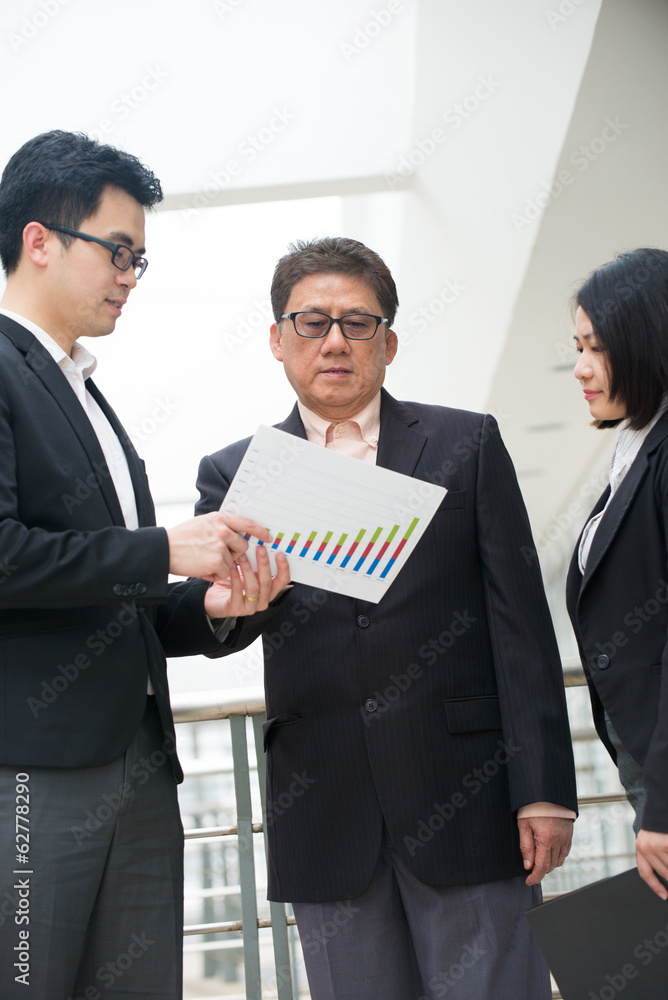 asian business team reporting to senior ceo with office backgrou asian business team reporting to senior ceo with office backgrou