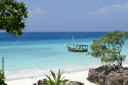 Beach and boat on turquoise water in Zanzibar, Tanzania, Africa