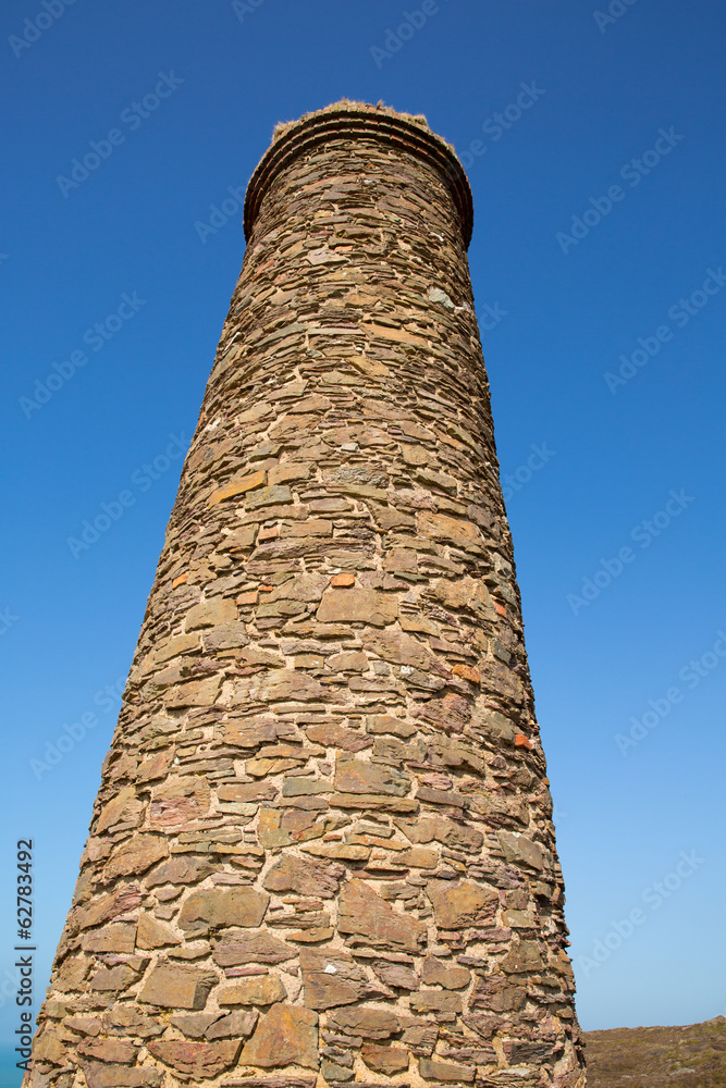 Tall industrial chimney and blue sky from tin mine