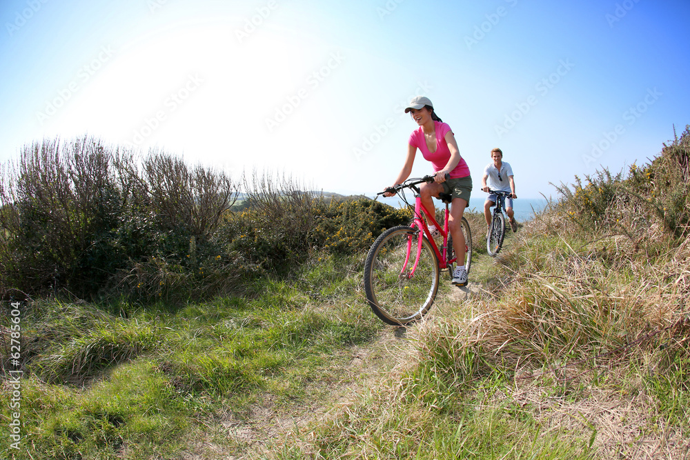 Couple riding bike on country path Couple riding bike on country path