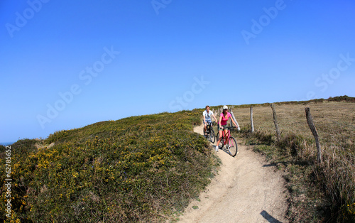 Couple riding bike on country path