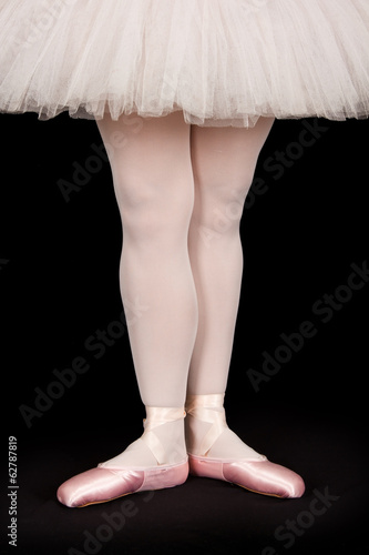 Ballet dancer standing on black floor while dancing artistic con