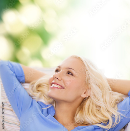 smiling young woman lying on sofa
