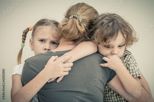 Obraz na plátně sad children hugging his mother