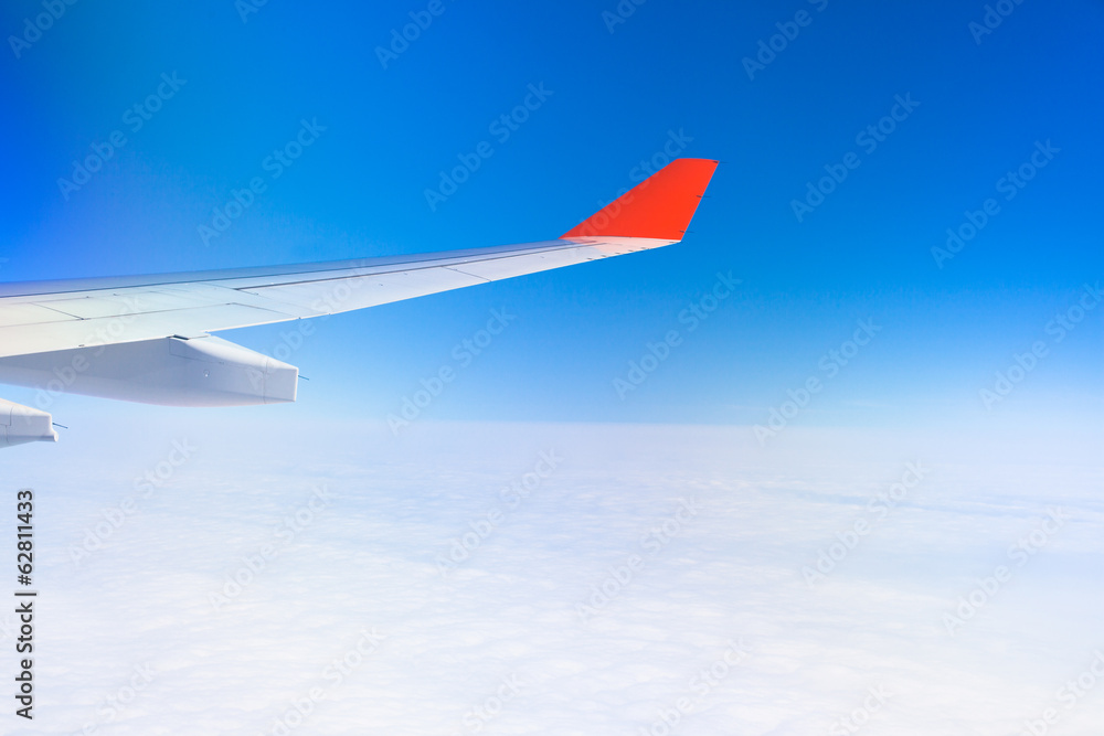 View from airplane window with blue sky and white clouds. Orange View from airplane window with blue sky and white clouds. Orange