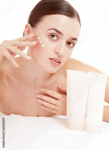 Woman applying moisturizer cream on face. Skin care consept.