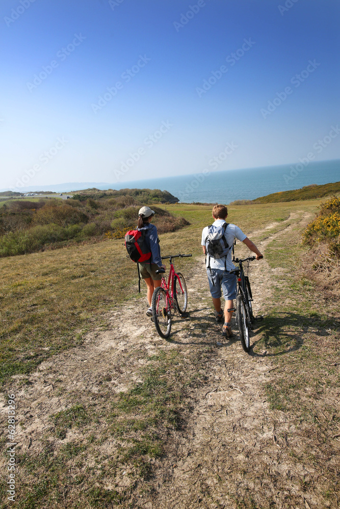 Couple walking in countrypath with bikes Couple walking in countrypath with bikes