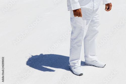 A man in white overalls, a race official timekeeper at a car racing event,  at Speed Week on Bonneville Salt Flats. photo