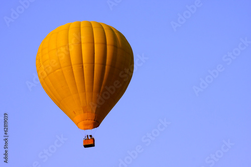 Yellow hot air balloon in blue sky