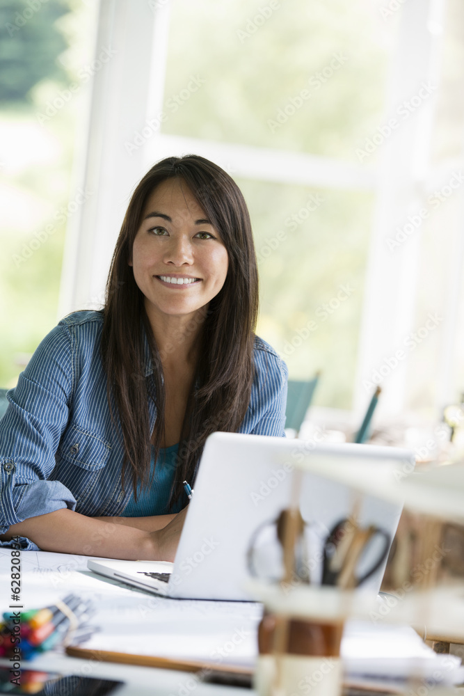 A woman in an office, working at a laptop computer. A woman in an office, working at a laptop computer.