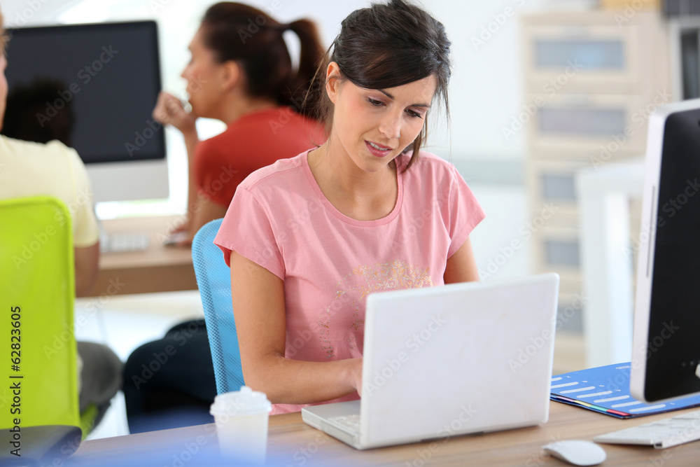 Fototapeta premium Young woman in business training with laptop