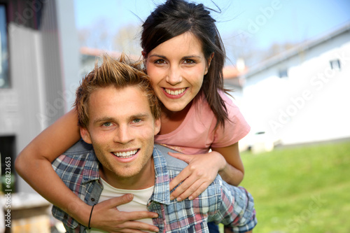 Φωτογραφία Young man giving piggyback ride to girlfriend