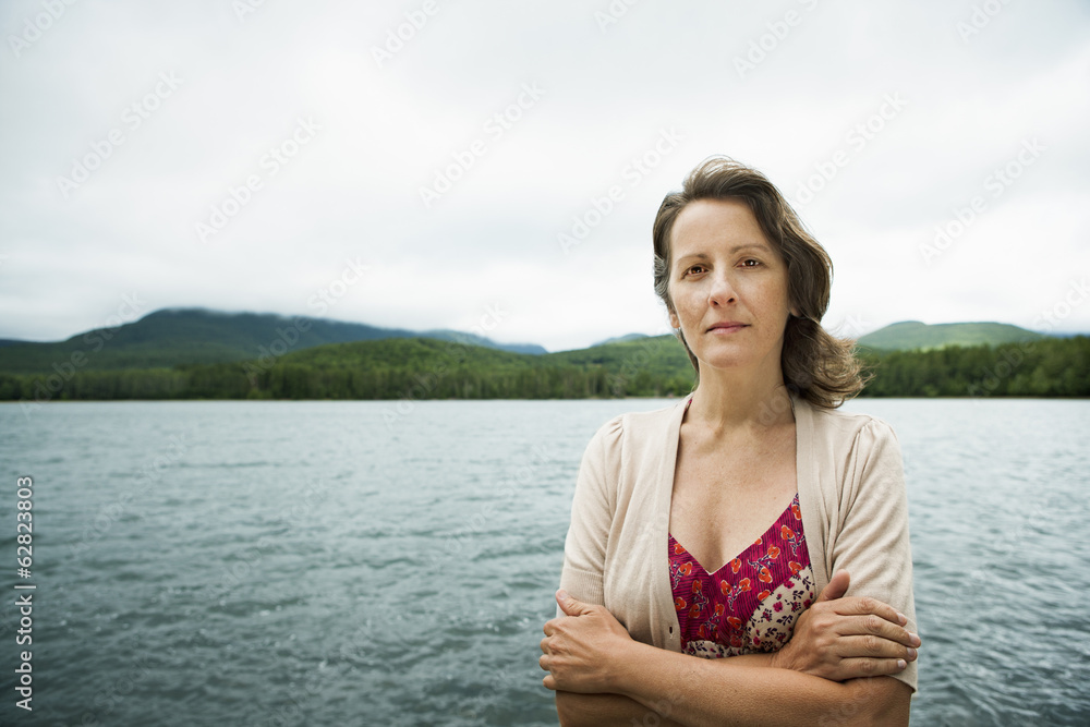 A woman in open countryside, by a mountain lake. A woman in open countryside, by a mountain lake.