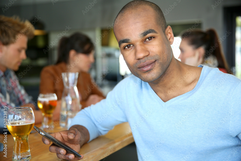 Man sitting at snack bar table checking messages Man sitting at snack bar table checking messages
