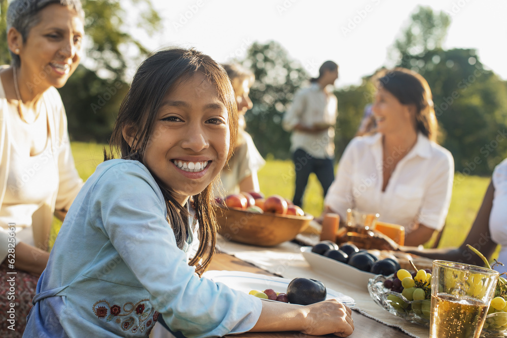 A family and friends having a meal outdoors. A picnic or buffet in the early evening. A family and friends having a meal outdoors. A picnic or buffet in the early evening.