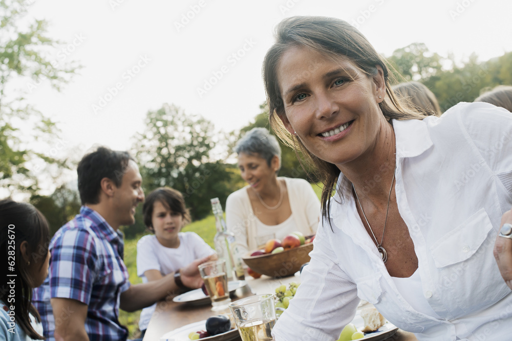 A family and friends having a meal outdoors. A picnic or buffet in the early evening. A family and friends having a meal outdoors. A picnic or buffet in the early evening.