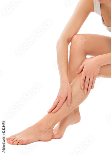 Woman touching hands and legs with french manicured nails