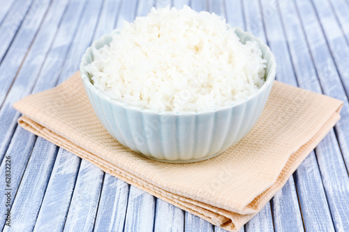 Cooked rice in bowl on wooden background