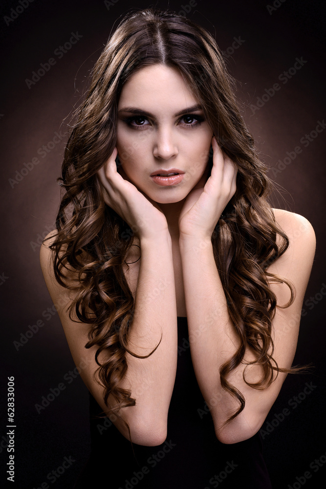 Beautiful young woman with long hair on dark brown background Beautiful young woman with long hair on dark brown background
