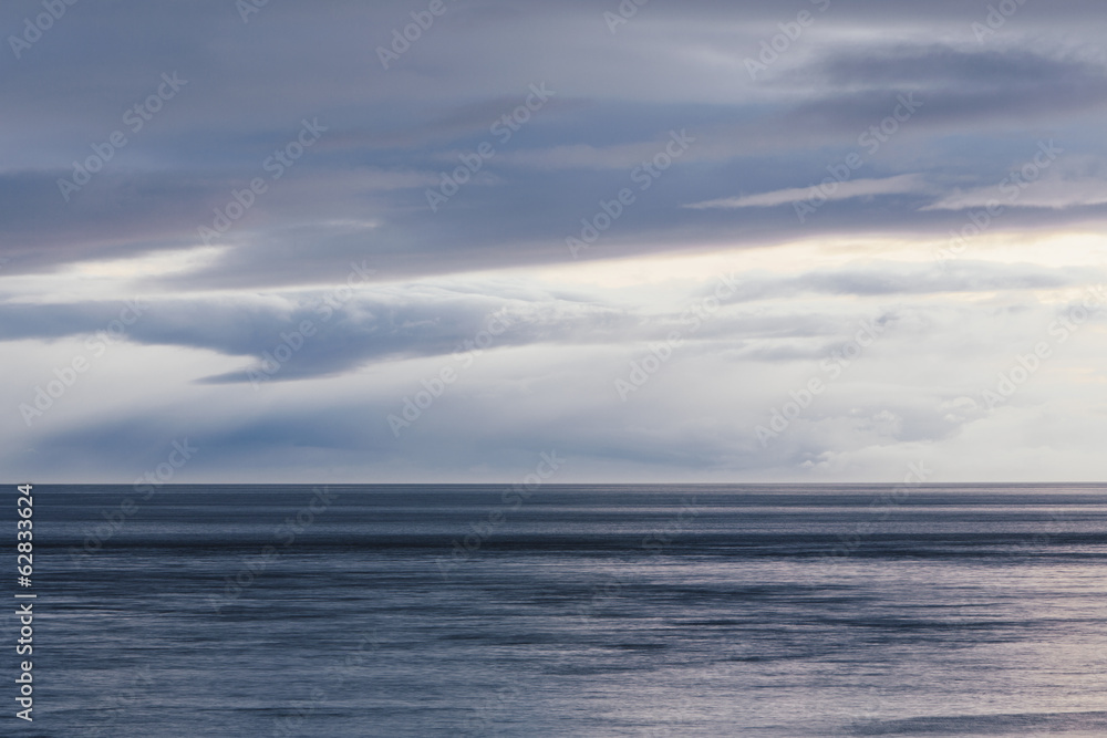 The sea and sky over Puget Sound in Washington, USA. The horizon with light cloud layers above. The sea and sky over Puget Sound in Washington, USA. The horizon with light cloud layers above.