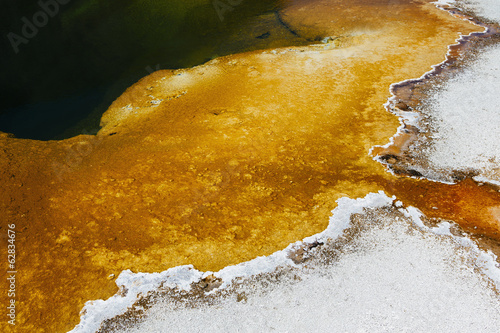 Detail of colorful water mineral deposits and rock formations from Midway Geyser, in Yellowstone National Park. photo