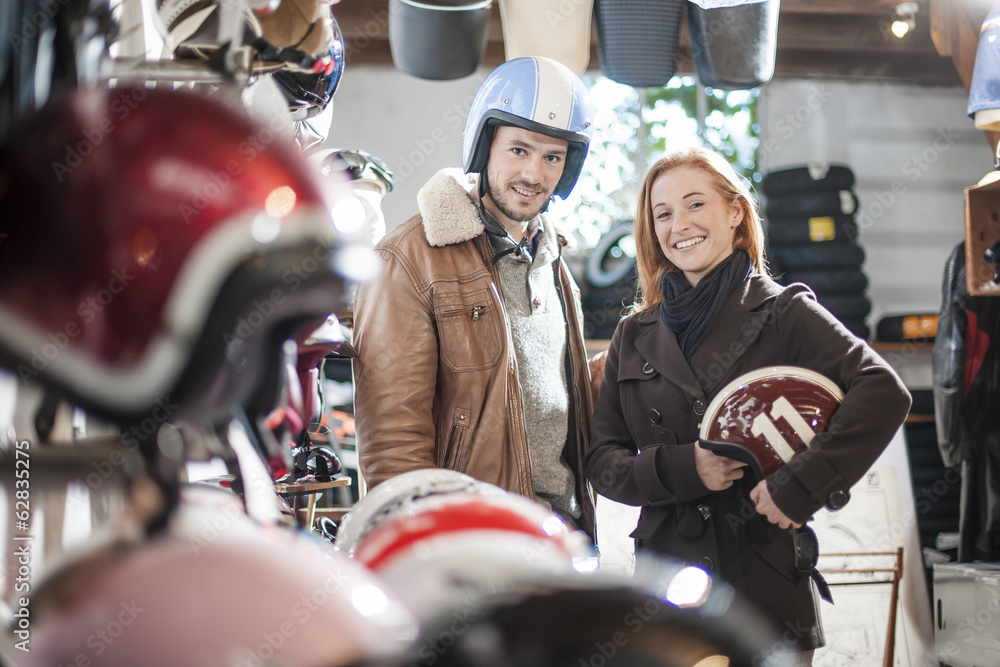 handsome couple choosing a trendy motorcycle's helmet in a speci