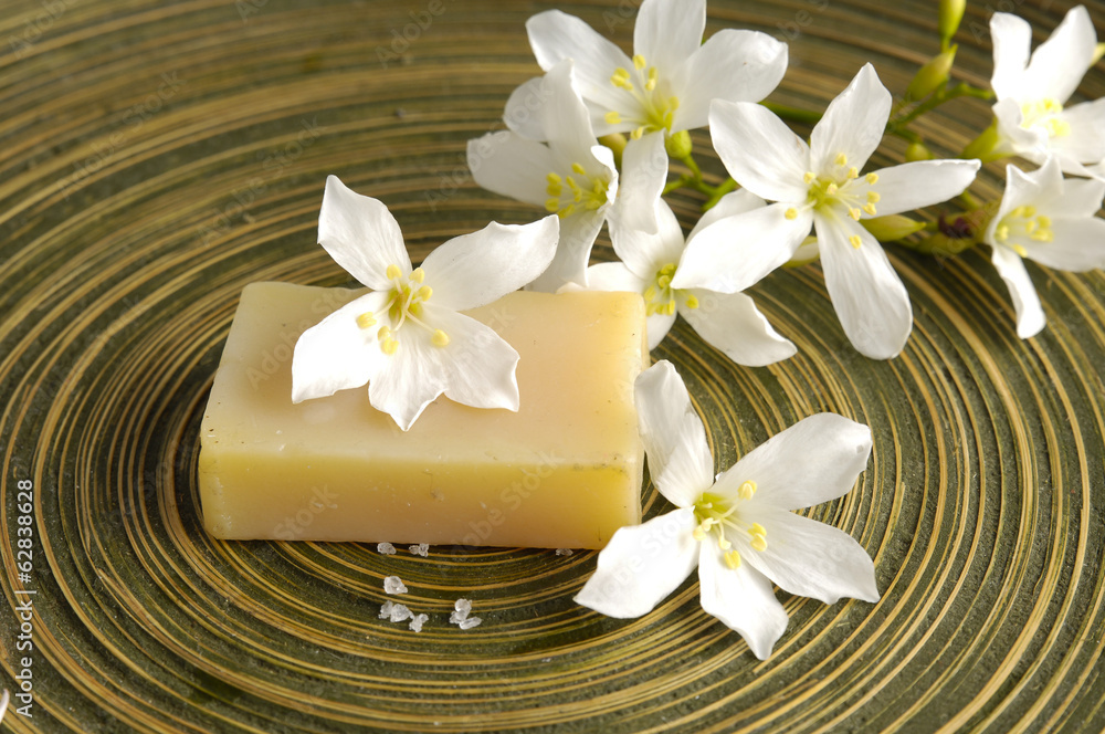 White frangipani and soap in wooden bowl