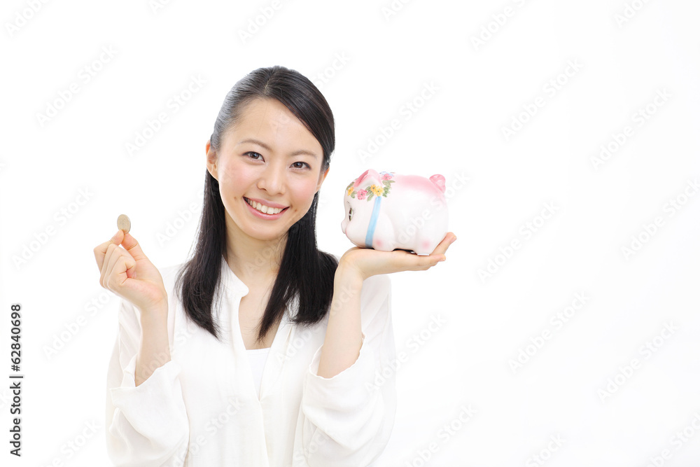 硬貨と貯金箱を持つ女性