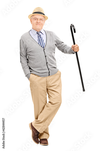 Senior gentleman with cane, leaning against a wall