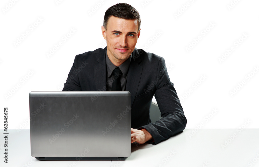Smiling businessman sitting at the table with laptop Smiling businessman sitting at the table with laptop