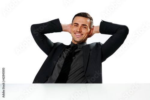 Relaxed smiling businessman sitting at the table 