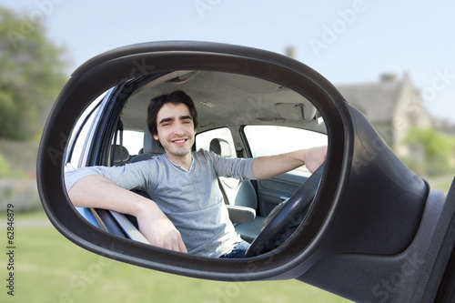 Billede på lærred Portrait through the rear-view mirror of an attractive man in hi