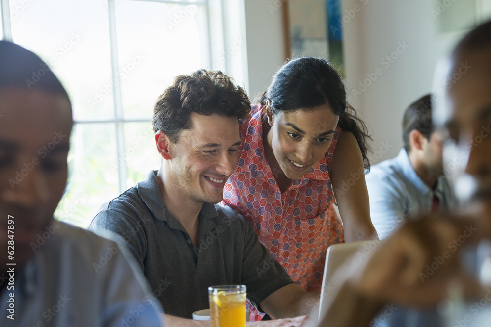 A group of men and women in a cafe, having drinks and enjoying each other's company. A group of men and women in a cafe, having drinks and enjoying each other's company.