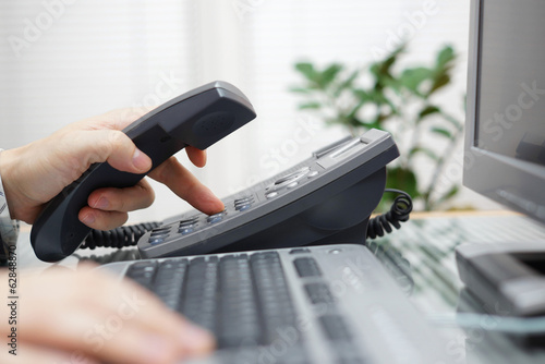 businessman is dialing a phone number in office photo
